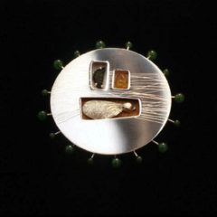 5.92 'Fruits of the Forest' 1997. Brooch; white metal, tourmaline, amber nephrite